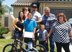 Photo By: K.P. Sander Christian Jimenez poses with his family as they celebrate his win in the Eastvale News Essay Contest.