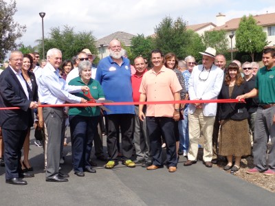 Photo By:  Emily Aguilar Mayor Ike Bootsma stands center as Jon Harrison, Chairman of the Sana Ana River Trail & Partnership, gets ready to cut the ribbon officially opening a new portion of the trail.  