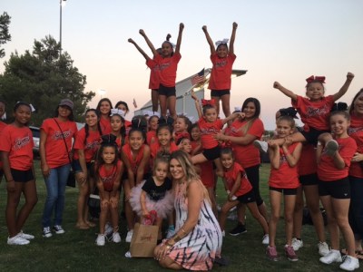 Photo courtesy: JCSD Local Synergy cheer and dance team posed with 3-year-old Finley Smallwood and her mom Christina at the 65th Street LIVE Concert in the Park in Eastvale. The event was organized by JCSD so the community could dance for Finley and help raise money for her surgery.